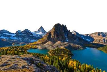 Lago turquesa al pie de picos nevados, con bosque de otoño en la orilla