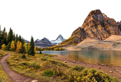 Lago de montaña entre pinos amarillos y una roca rojiza con un sendero de tierra en primer plano