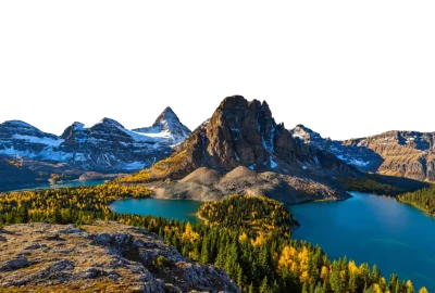 Lago turquesa al pie de picos nevados, con bosque de otoño en la orilla